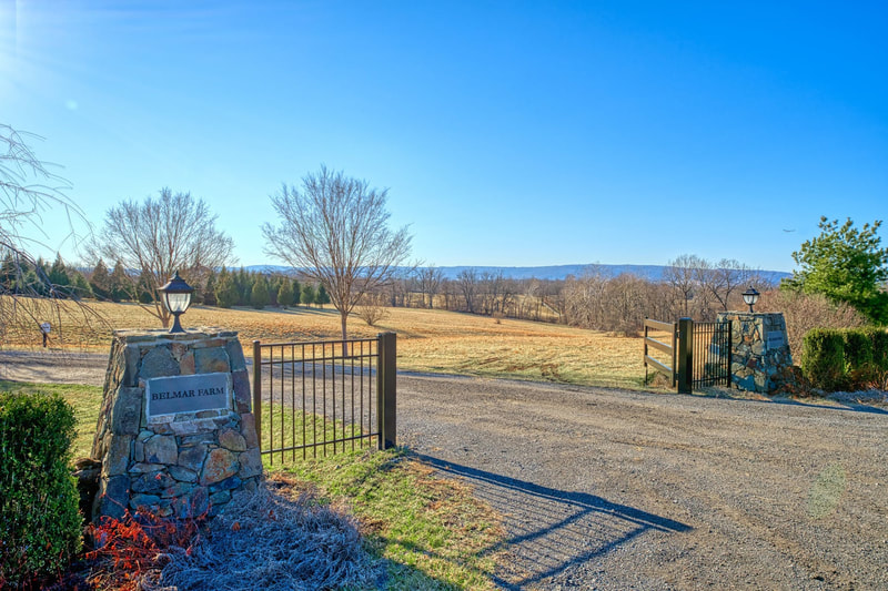 The gates to Belmar Farm with the Blue Ridge Mountains in the background