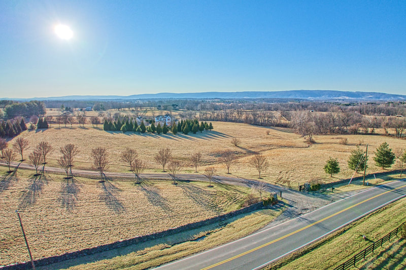 A drone image taken from St. Louis Road of the entrance to Belmont Farm