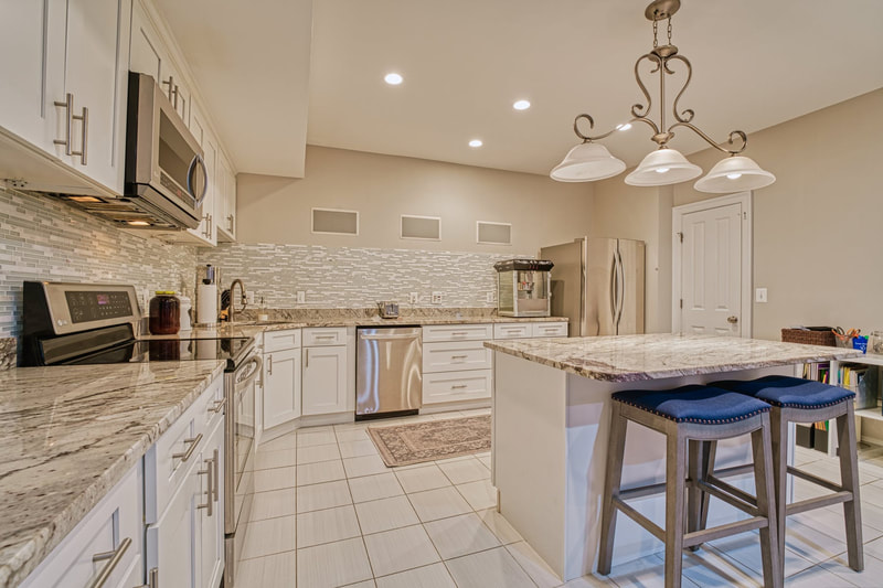 The kitchen in the lower level has tile flooring, a center island and very nice marble countertops